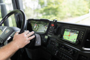LKW-Fahrer im Führerhaus mit Navigationsgeräten
